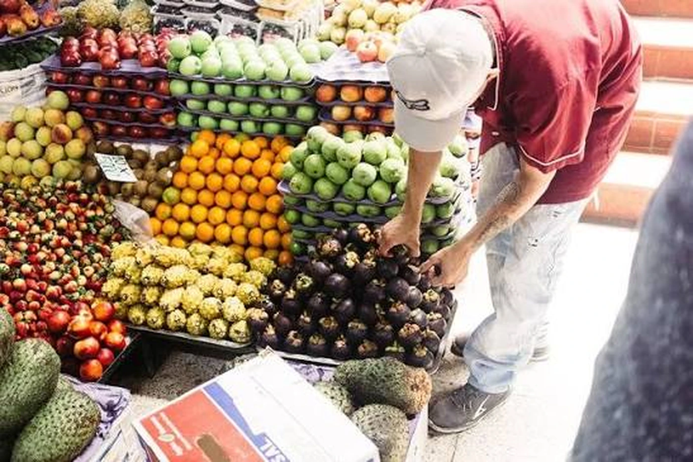 Fresh fruit being hand-picked from a market display